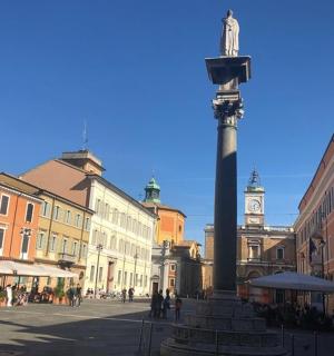 městská ulice s velkým sloupem s hodinovou věží