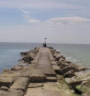a pier in the ocean with a lighthouse on it