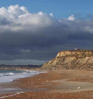 a beach with a rocky shoreline with a mountain