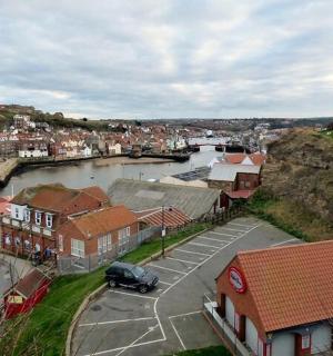 a small town with a river and buildings and cars