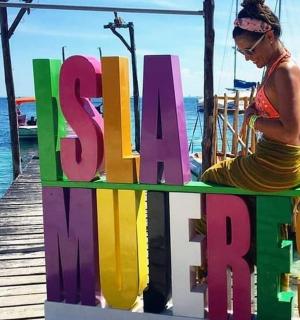 一位女士坐在水边的长椅上