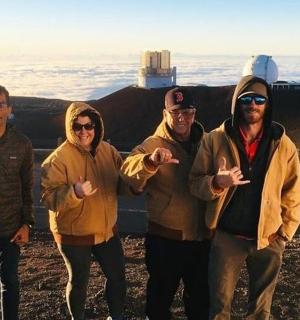 skupina lidí stojící na vrcholu hory