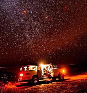 dodávka zaparkovaná pod hvězdnou oblohou v noci