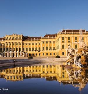 a large yellow building with a fountain in front of it