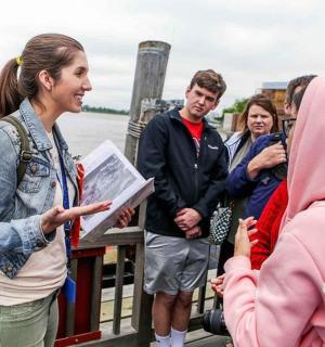 žena mluvící se skupinou lidí na molu