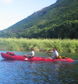 dva lidé v červeném kajaku na řece