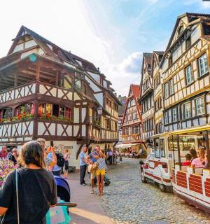 a group of people walking down a street next to buildings