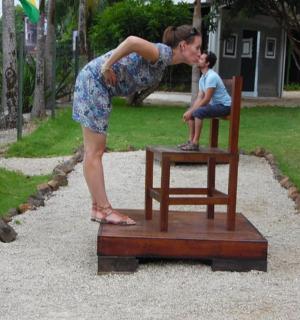 a woman standing next to a man sitting on a chair