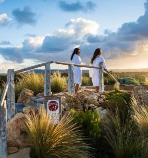 Dvě ženy v bílém stojící na dřevěném mostě