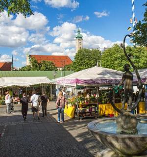 a market with a fountain in the middle of a street