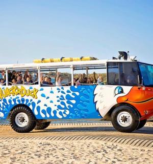 a bus on the beach with people in it