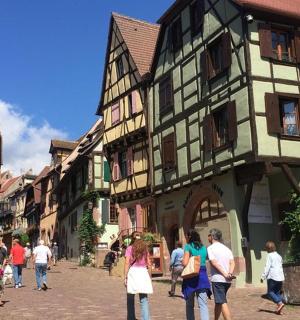 กลุ่มคนกำลังเดินไปตามถนนที่มีอาคาร