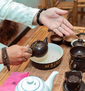 一位女士正端着碗里的茶壶