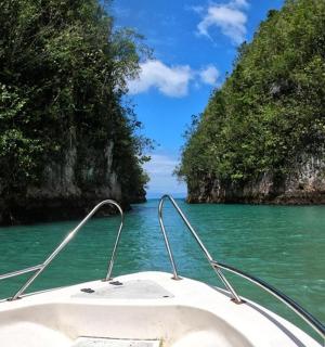 a boat in the water in front of a island