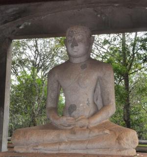 a statue of a person sitting in a meditation pose