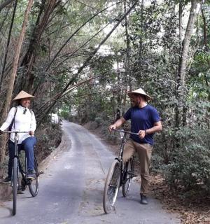 a man and a woman riding bikes down a road