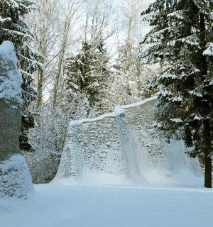 a snow covered park with a waterfall and trees