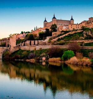 一座位于山上的城堡,旁边有一条河和一座桥