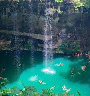 a waterfall in a pool with people swimming in it
