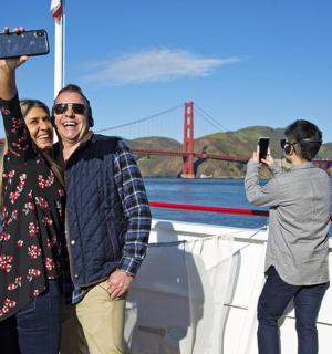 skupina lidí stojících na lodi s rukou ve vzduchu