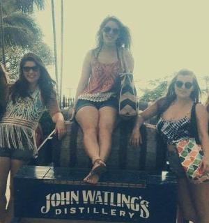 a group of women sitting on a sign on the beach