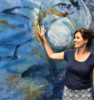 žena stojící před obrazem ryb