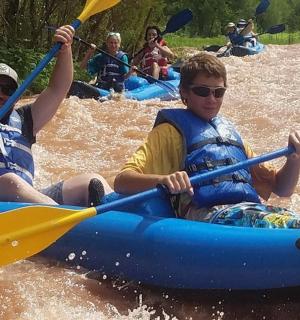 两名男子在水中的蓝色木筏上