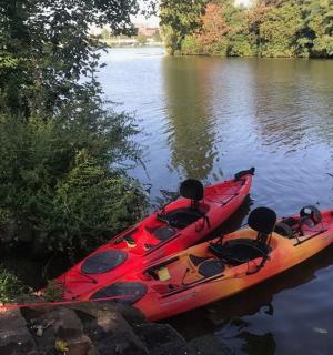 červený kajak sedící na břehu řeky