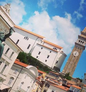 budova se sochou před hodinovou věží