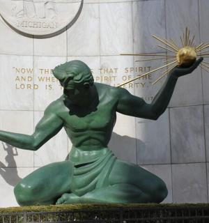 eine Statue eines grünen Mannes, der einen Ball hält