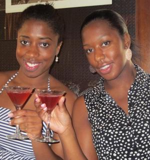 dvě ženy sedící na gauči a držící nápoje