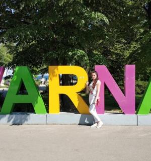a woman standing in front of a large sign