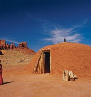 žena stojící před budovou v poušti