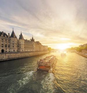 a boat traveling down a river in front of a building