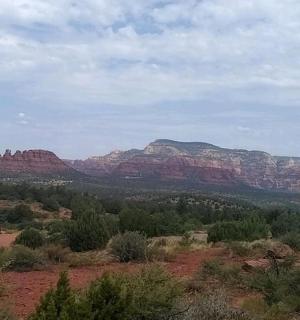 一辆汽车停在田野里，背景是群山