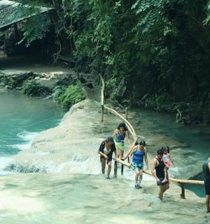 a group of people crossing a bridge over a river