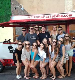 a group of people posing in front of a car