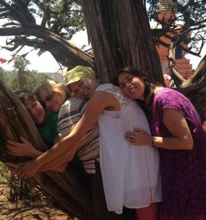 čtyři ženy objímající se na stromě