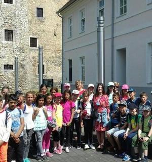 建物の前で写真を撮る子供たちのグループ