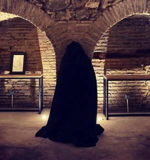 a person in a dark room with two tables