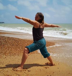 一位女士站在海滩上,张开双臂