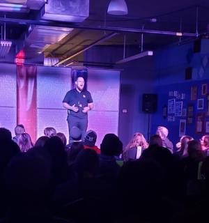 一名男子站在舞台上，面对着一群人