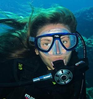 eine Frau mit Tauchermaske und Taucherbrille unter Wasser