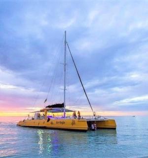 a yellow boat sitting on the water at sunset