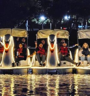 一群人坐在水上的天鹅船上