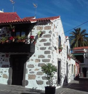ein Steingebäude mit einem Balkon mit Blumen darauf