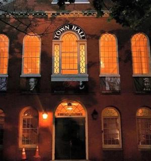 一栋砖砌建筑，窗户上亮着橙色的灯光