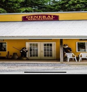 dva lidé sedící na židlích před žlutou budovou