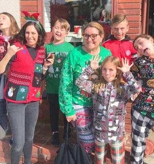 a group of people in christmas sweaters posing for a picture
