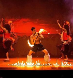 muž tančící na pódiu s ohňovými umělci